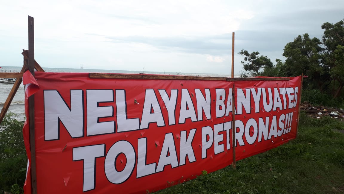 Nelayan Banyuates bentangkan sepanduk penolakan pertambang minyak dan gas oleh Petronas. (Foto: Beritabaru.co/ Ulfatus Soimah)