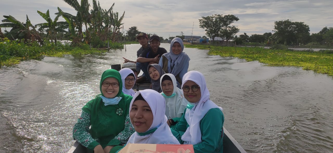 Naik perahu, PAC Fatayat dan PAC IPPNU Kalitengah terjang banjir bagikan puluhan paket sembako.
