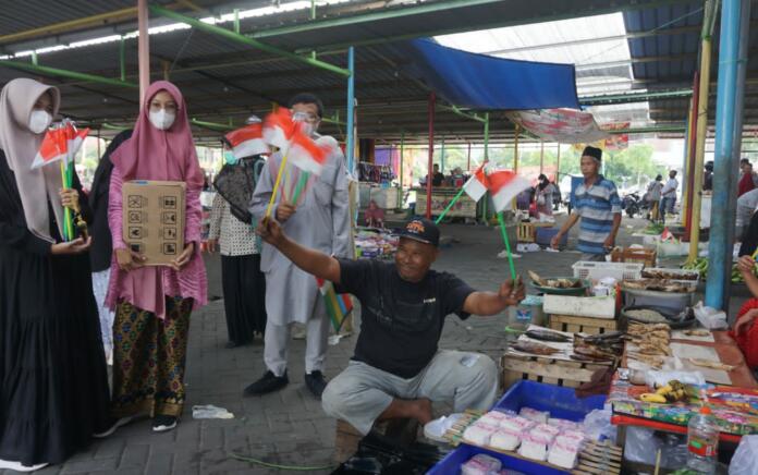 Hari Kemerdekaan, Pelajar di Gresik Bagikan 770 Bendera Merah Putih ke Pedagang